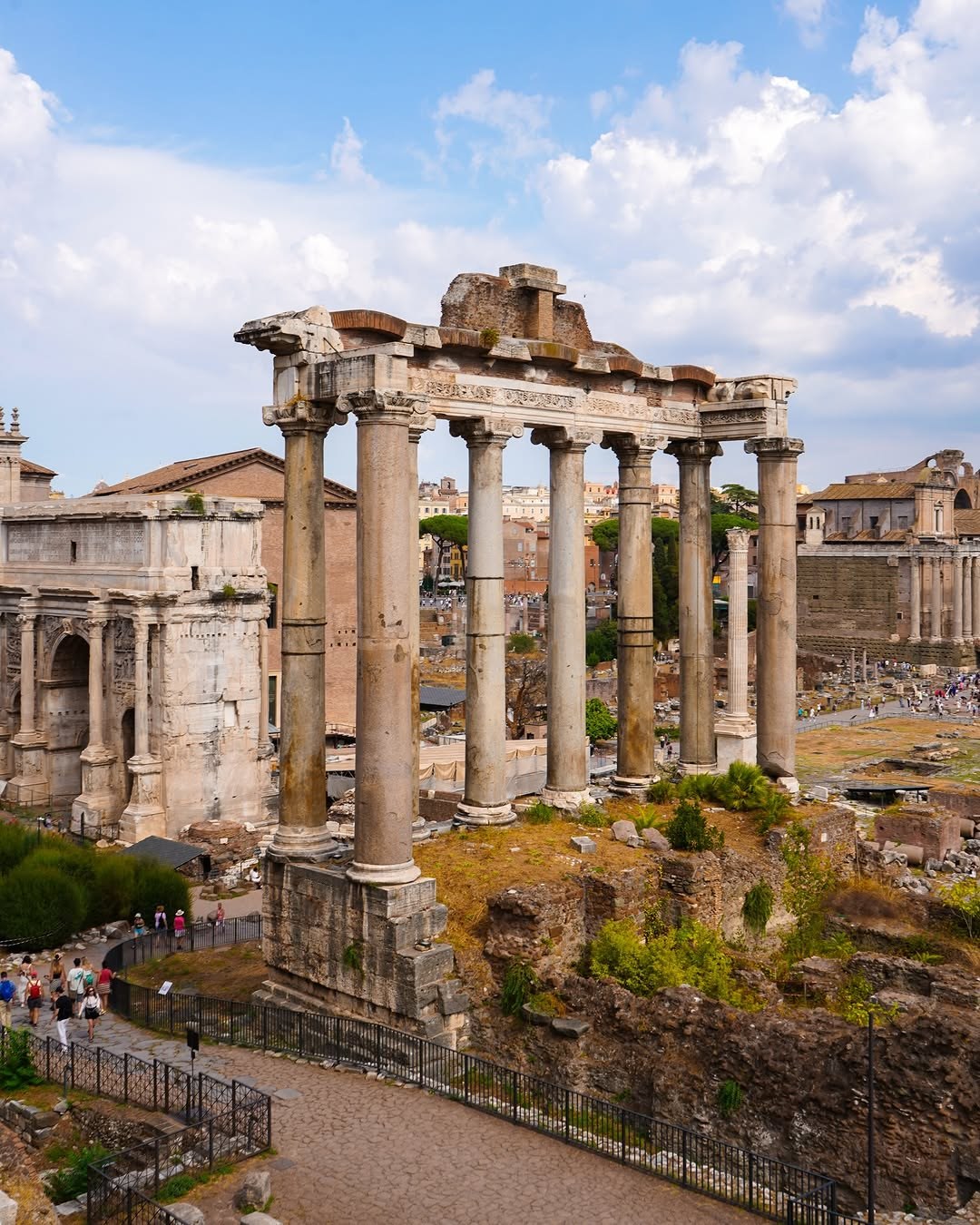 The columns of the Temple of Saturn in the Roman Forum under a blue sky