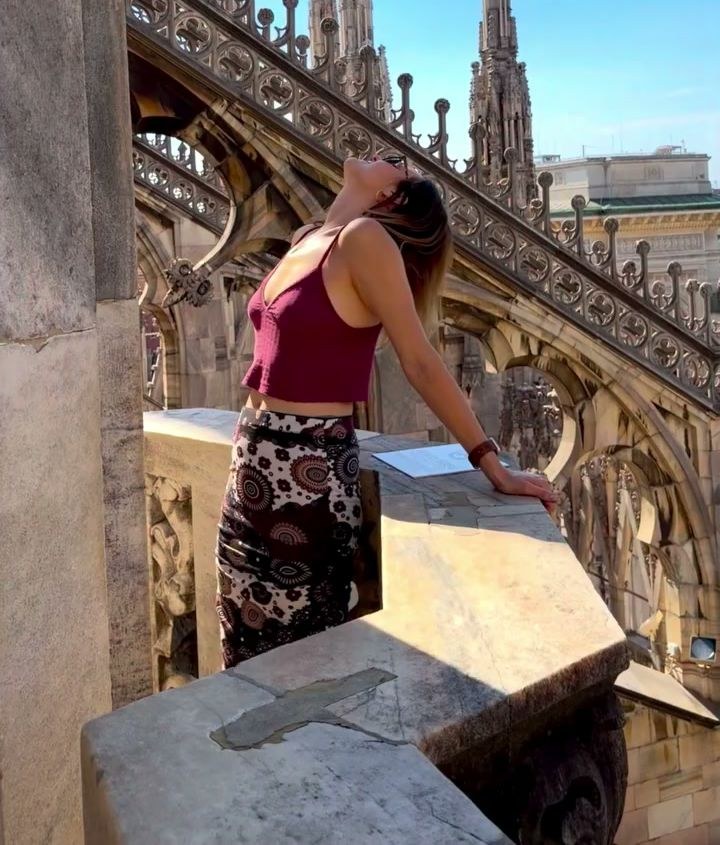 Polina leaning on a marble balustrade on the rooftop terraces of the Duomo di Milano