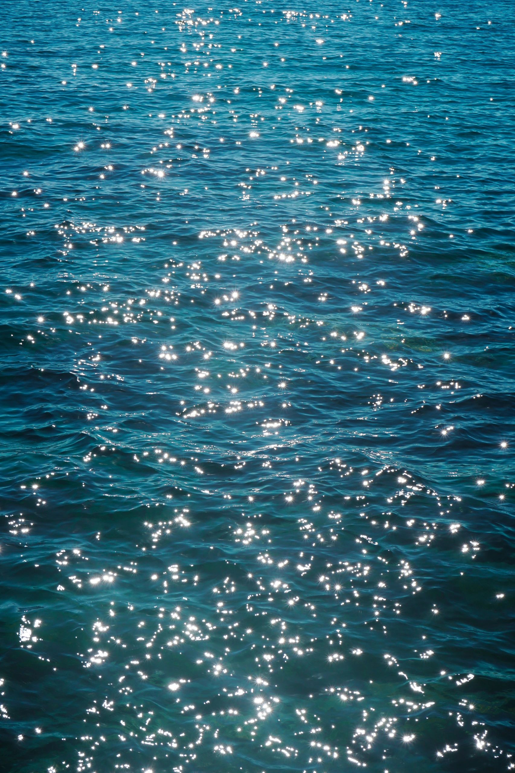 Brillo del sol reflejándose en el agua del mar.