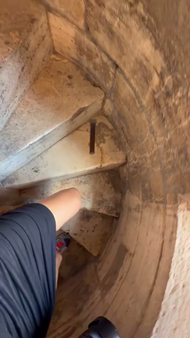 Looking down the narrow spiral staircase inside the Facciatone in Siena