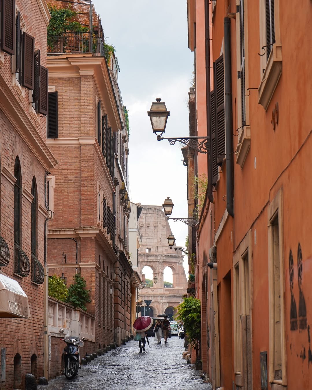 A narrow Rome street with the Colosseum at the end of it