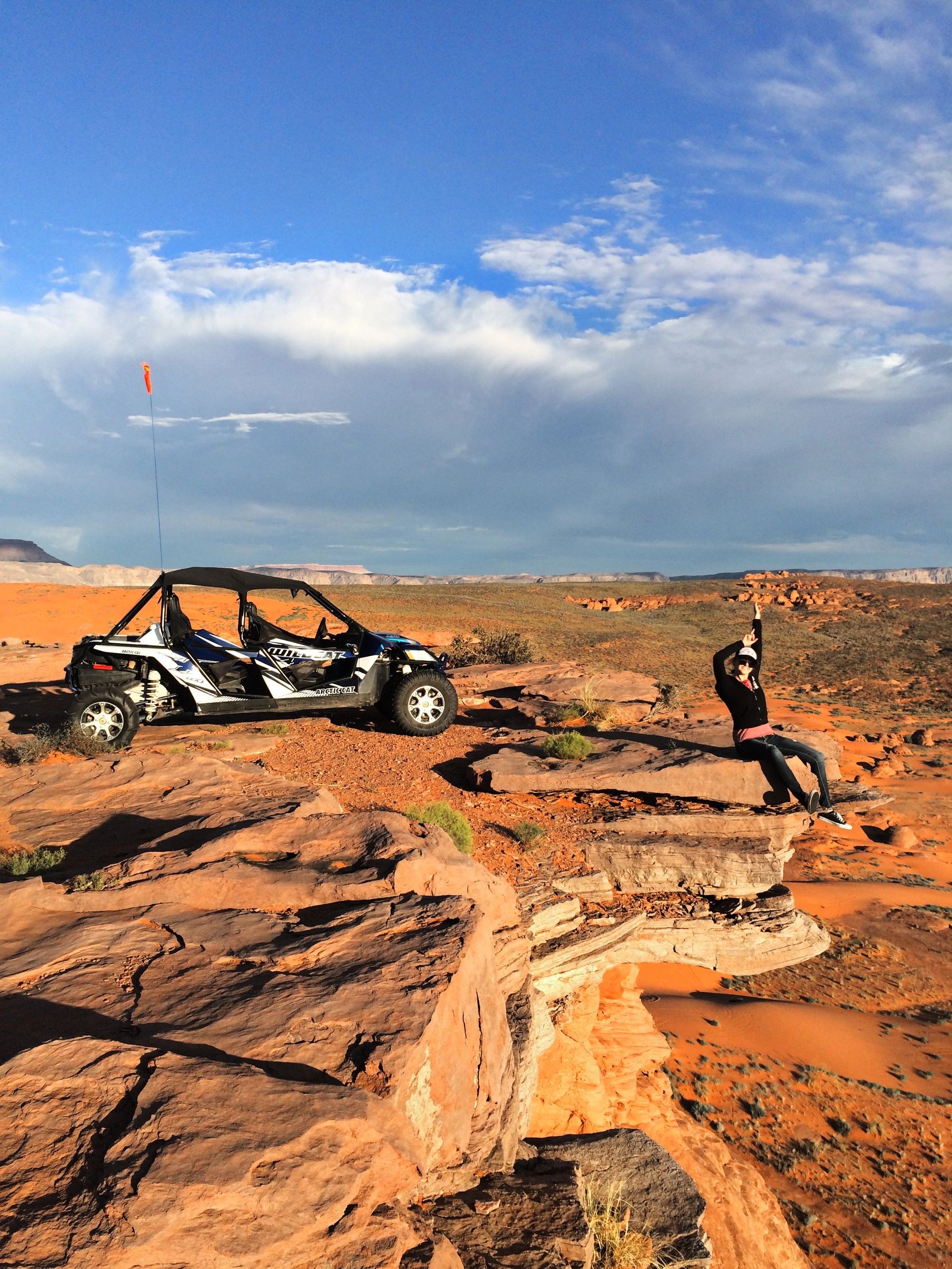 A girl is looking at view and sitting on a cliff after 4 wheeling in Sand Hallow State Park