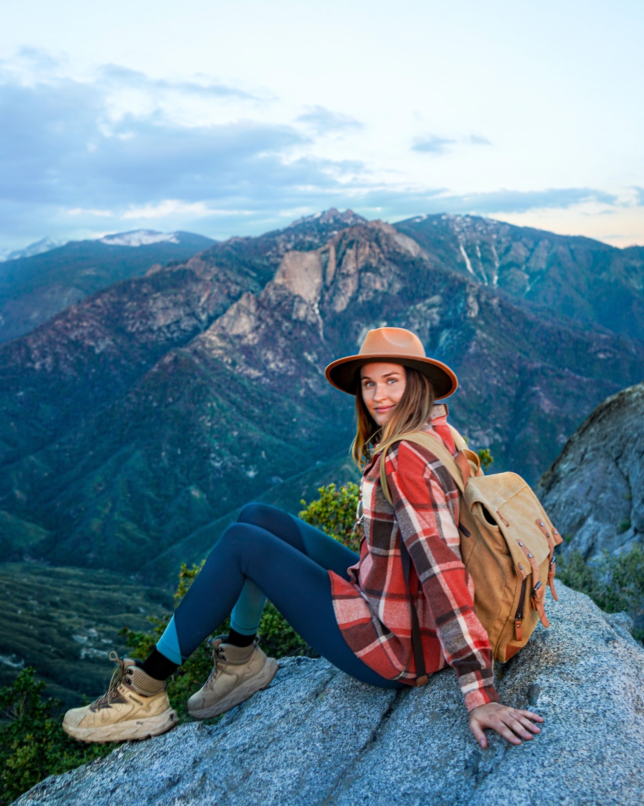 Polina sitting on a rock overlooking the mountains
