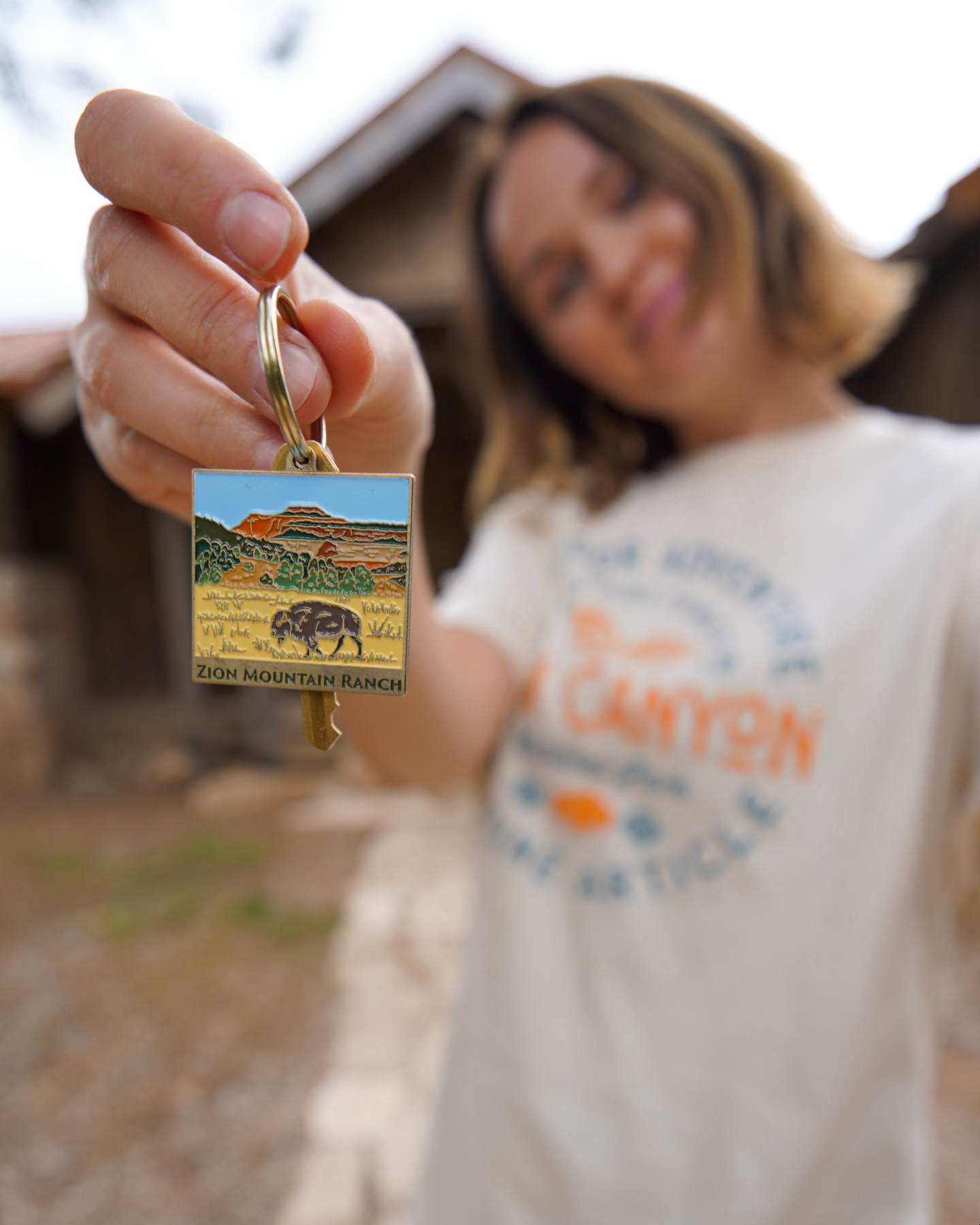 Polina holding out a cabin key on a Zion Mountain Ranch keychain