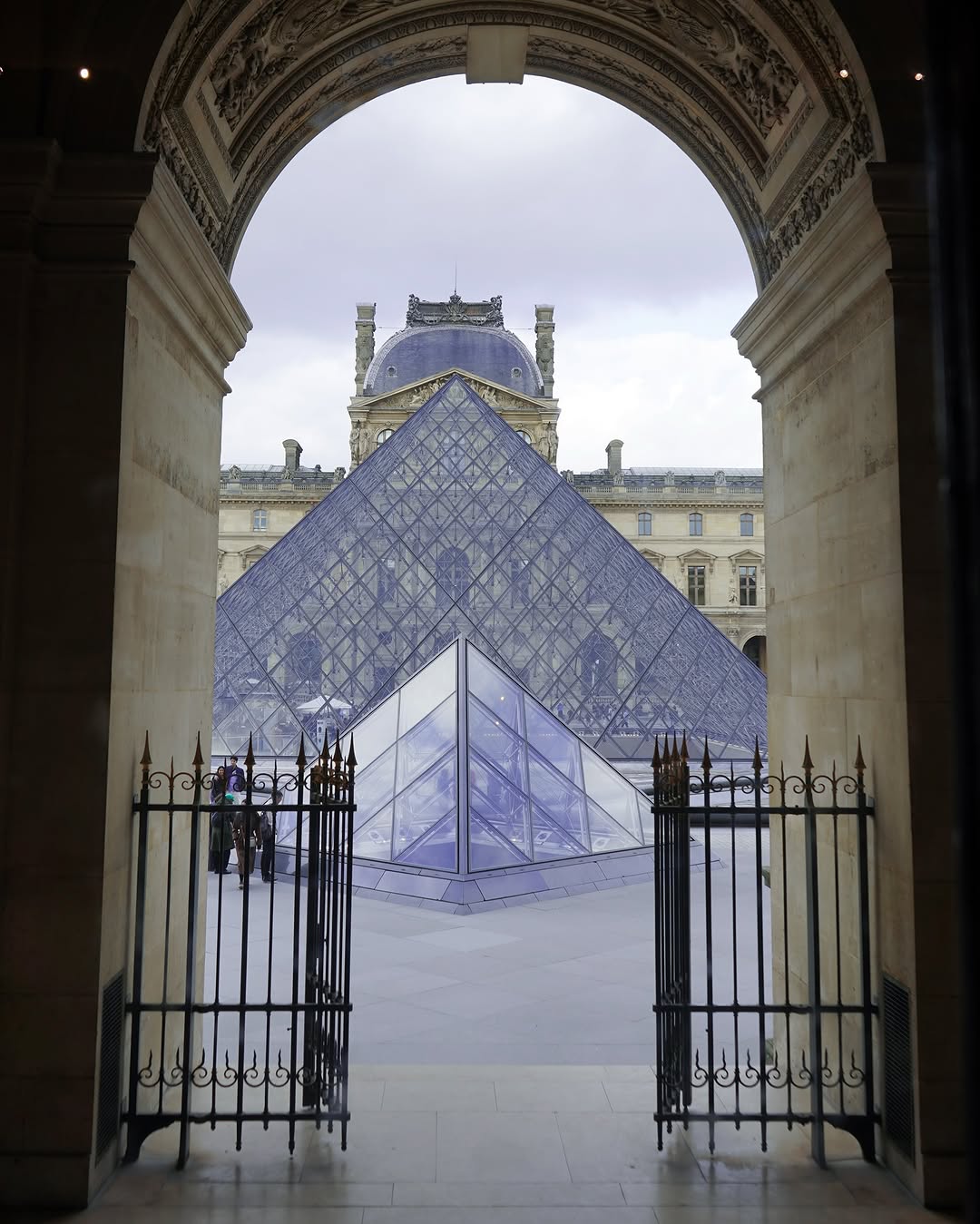 Polina walking inside a gallery of the Louvre, surrounded by paintings