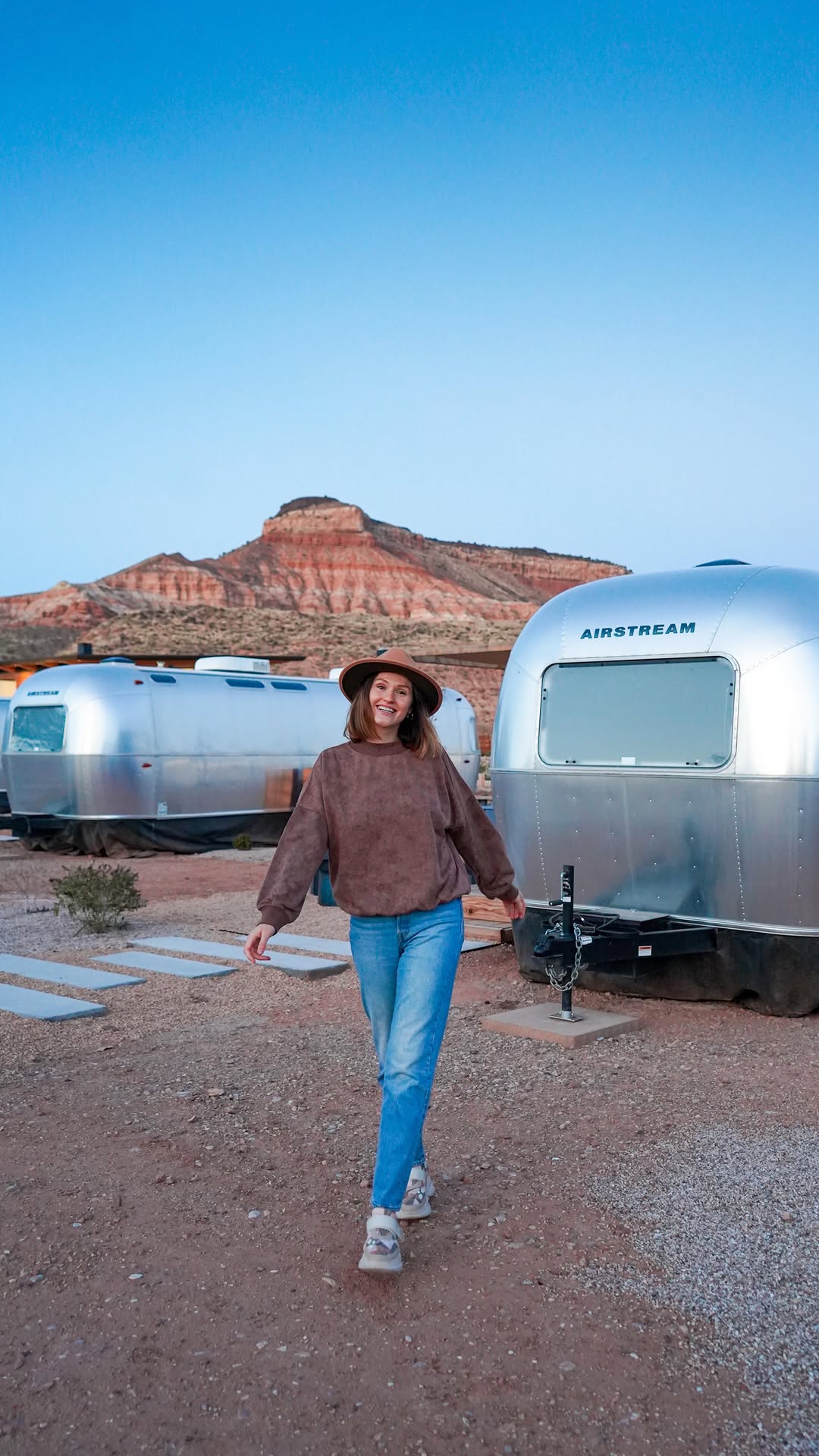 A polished silver Airstream trailer at AutoCamp Zion with red cliffs in the background