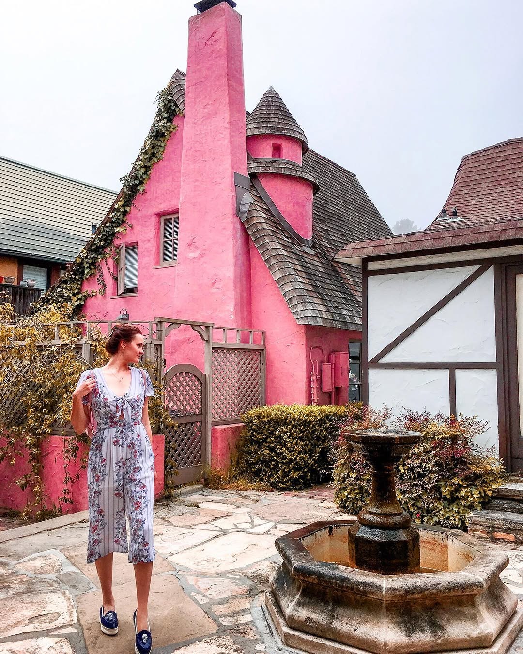 Polina in front of a pink storybook cottage in Carmel-by-the-Sea