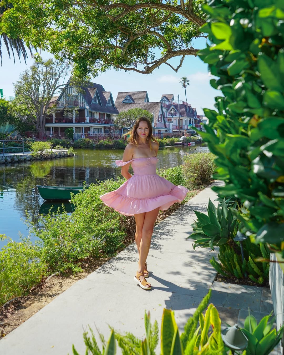 Polina twirling in a pink dress beside the Venice Canals