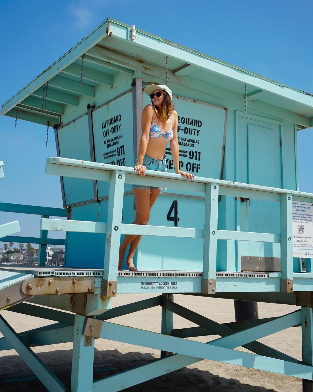 Polina on a blue lifeguard tower on the beach in Los Angeles