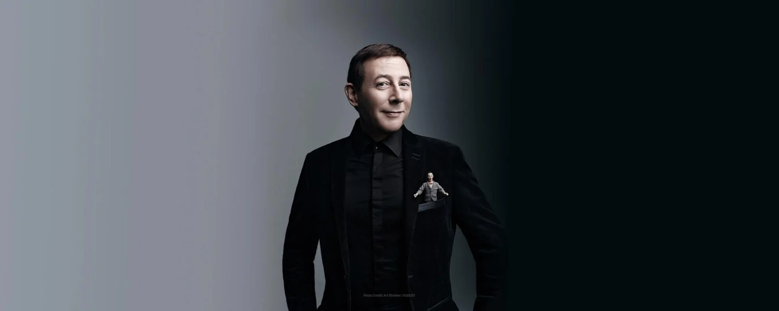 Paul Reubens in a black suit