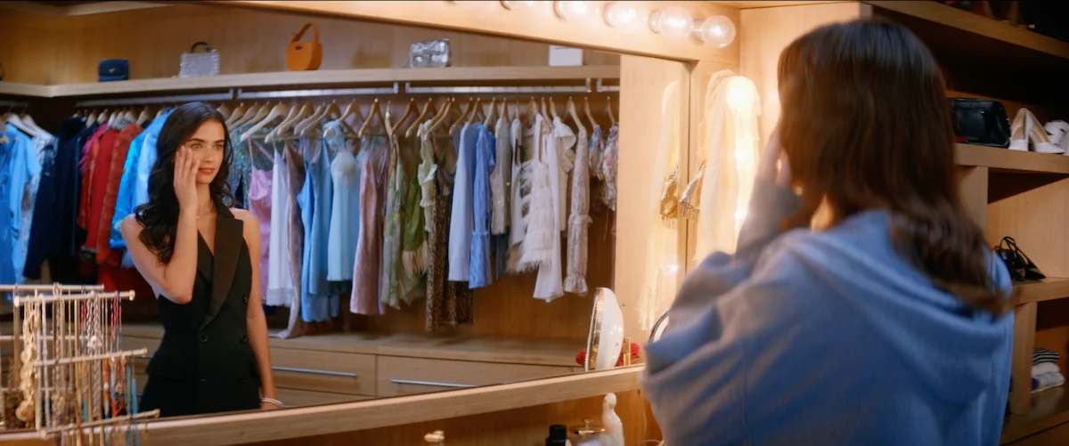 Still from IDYLL: a woman in a black dress stands in a walk-in closet, facing a woman in a blue hoodie