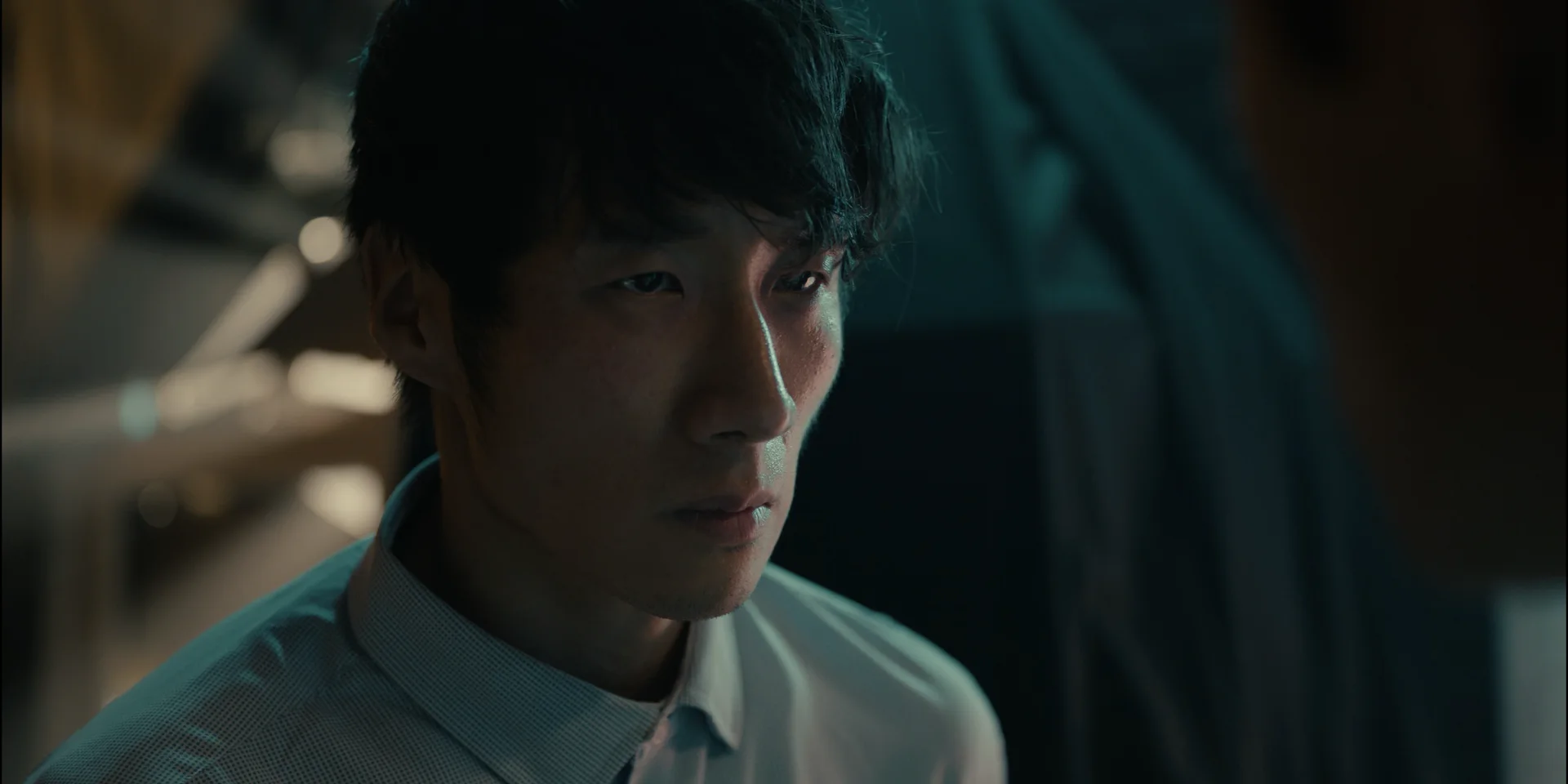 Still from DON'T TOUCH ANYTHING: close-up of a young man in a white collared shirt looking to the side