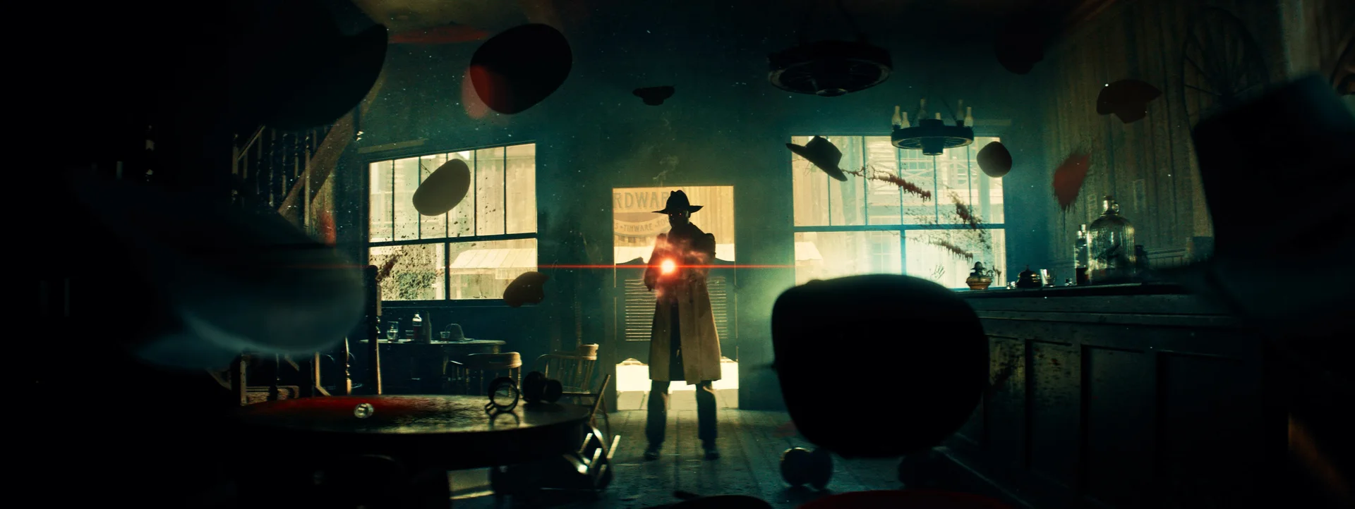 Still from THE LORD OF ALL FUTURE SPACE & TIME: the silhouette of a man in a cowboy hat holds a glowing red light in a room where objects float in the air